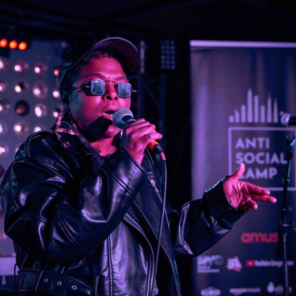 A woman singing into a mic during a live performance.