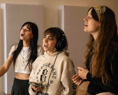 three artists singing together happily