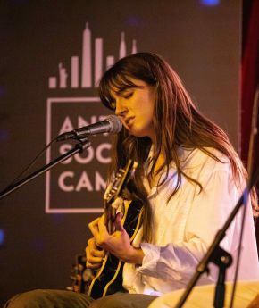 an artist playing guitar and singing