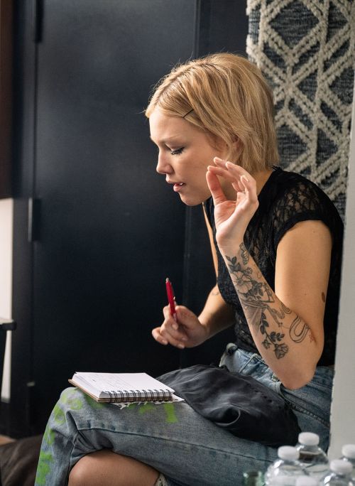 artist with a notebook singing while writing a song